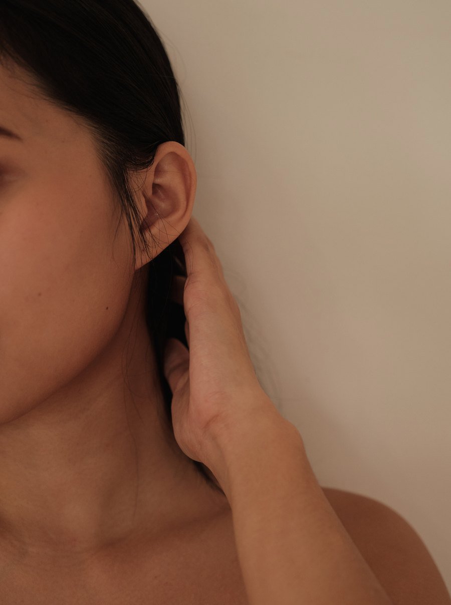 Mujer colocándose el pelo detrás de la oreja